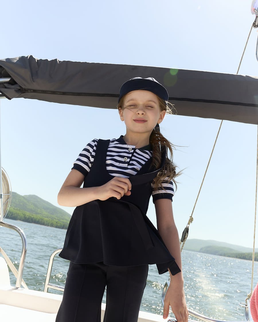 Navy peplum vest look, smiling under the boom