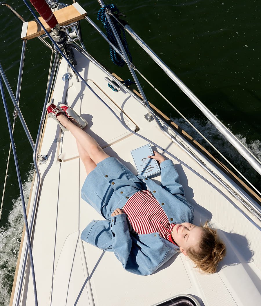 Girl lying on deck reading, aerial view